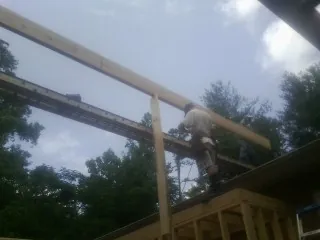 Carpenter setting a ridge beam over a new addition frame — Ice Dam Removal by Roofing Brothers in Budd Lake