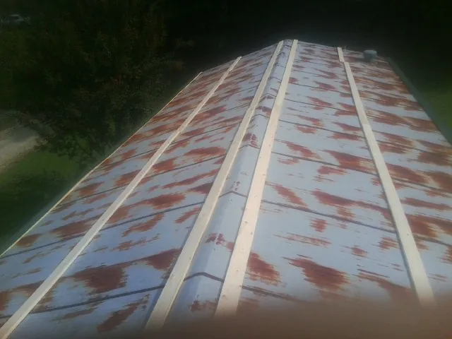 Rusted metal roof panels with new wood purlins before replacement — Storm Damage Roof Repair in Budd Lake by Roofing Brothers