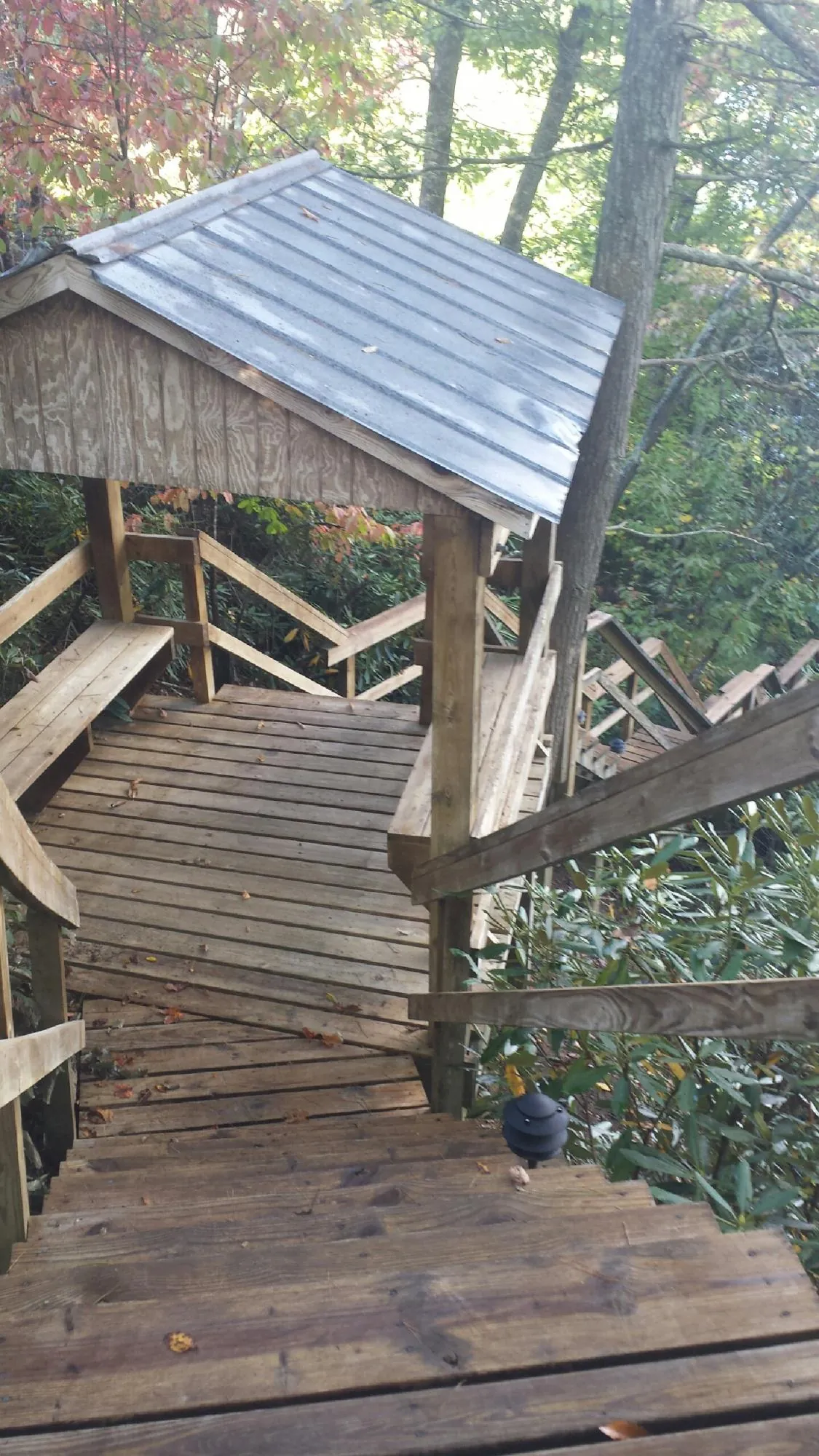 Metal roofed shelter over wooden steps on a wooded walkway — Skylight Repair & Installation work by our crew in Budd Lake