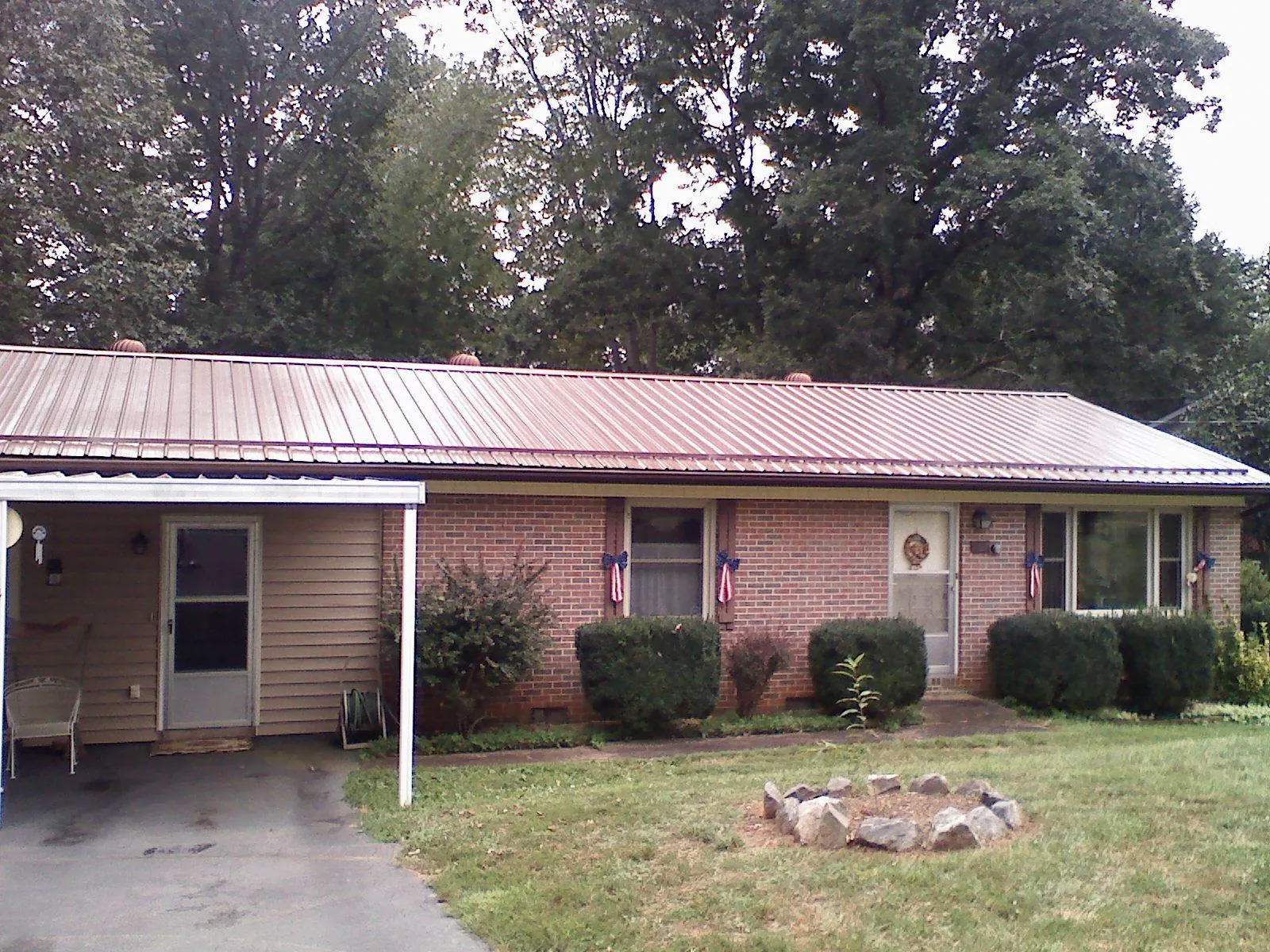 Bronze metal roof and carport on a brick ranch home — Roof Repair work by our crew in Budd Lake